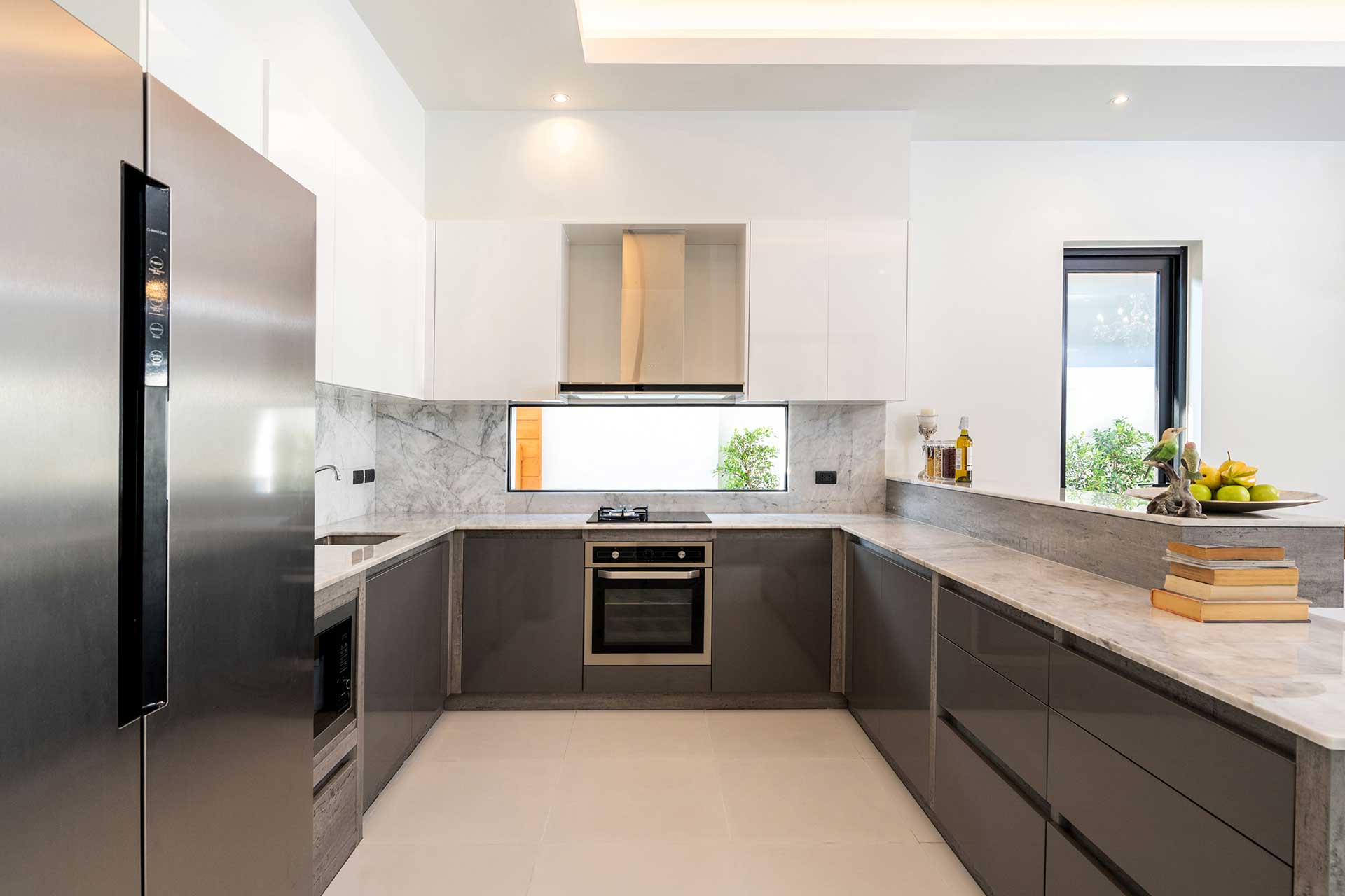 Modern kitchen with bottom black cabinets and top white cabinets, without handles and cream counters
