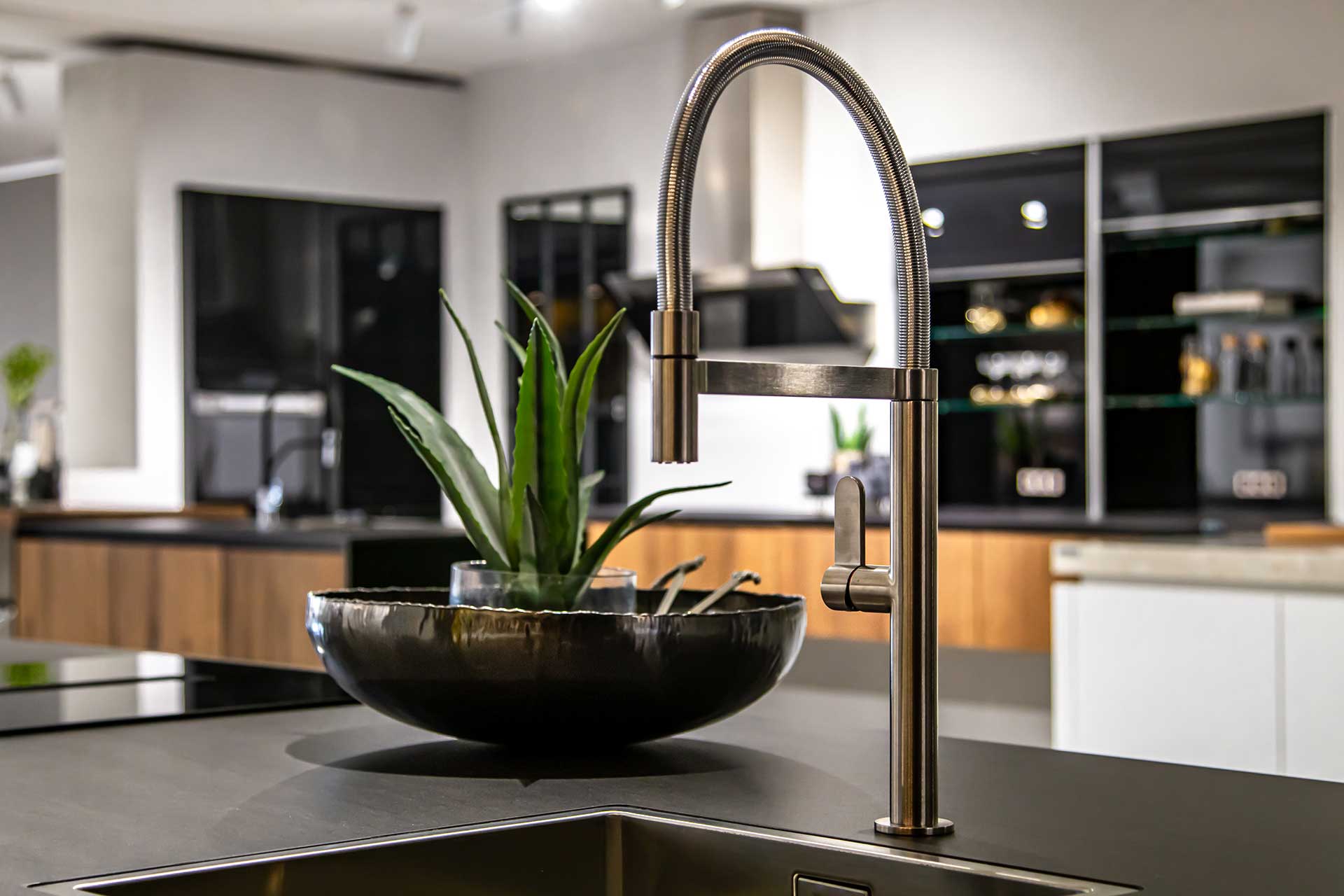 Golden tap on a black kitchen sink
